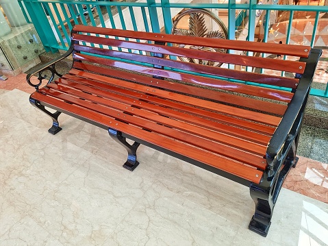 Jakarta, Indonesia - Mar 19, 2024: Wooden brown indoor bench with no people sit on it in a shopping mall
