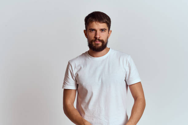 istock Muscular man in a white t-shirt on a light background cropped view 2104369746