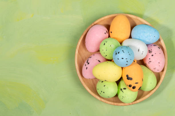 istock Color decorative Easter eggs on wooden plate on green yellow background. Top view. Copy space. 2104380771