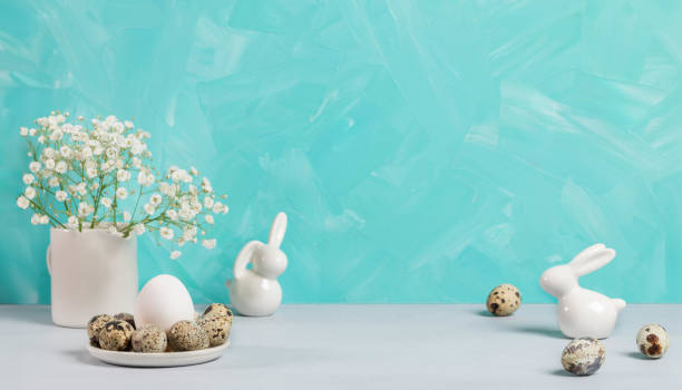istock Easter card template Eggs, ceramic bunnies, white gypsophila. Turquoise background as space for text 2104380776