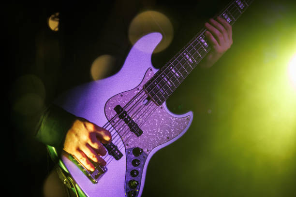 музыкант играет на бас-гитаре на сцене рок-фестиваля. - blur band стоковые фото и изображения