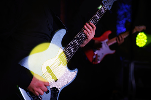 Close-up of a bass guitar during a concert performance. Guitarist bass on stage