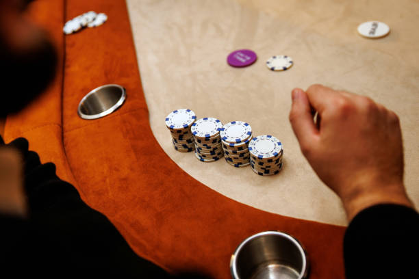The player hand is hovering over a stack of chips, ready to make the next big move.