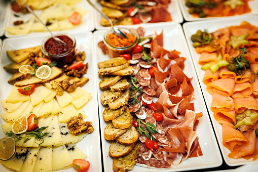 Spread of gourmet delicacies, featuring an assortment of finely sliced meats, artisanal cheeses