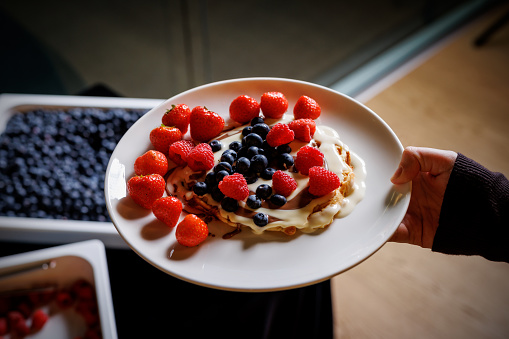 Golden Pancakes with Fresh Berries: A delectable dessert plate, showcasing a stack of golden pancakes lavishly topped with a generous serving of fresh strawberries and blueberries