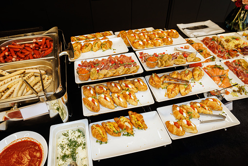 A lavish spread of gourmet appetizers, featuring golden croissants garnished with fresh herbs and a variety of delicious fillings