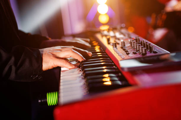 istock Musician hands on the modern piano keyboard keys, side view. 2104421869