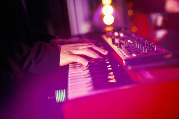 istock A musician plays modern piano keyboards during a concert performance. 2104421871