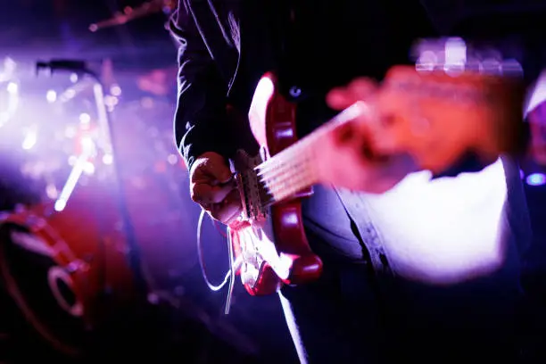 Photo of Close-up of a musician playing the electric guitar during a concert.