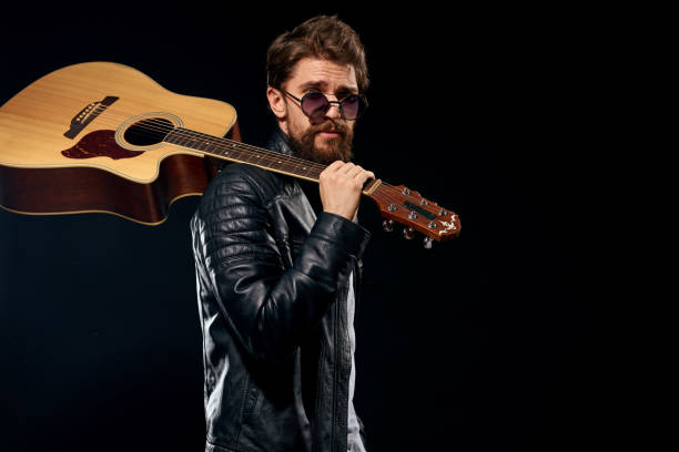 istock A man with a guitar in his hands leather jacket music performance rock star modern style dark background 2104451579