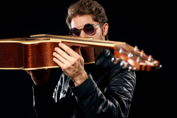istock A man with a guitar in his hands leather jacket music performance rock star modern style dark background 2104458507