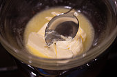 Melting butter in glass bowl over a pot of boiling water on gas stove. Cooking Salted Caramel Chocolate Cold Cake Series.
