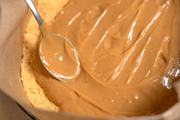 istock Line caramel sauce in springform with ground cookies base. Cooking Salted Caramel Chocolate Cold Cake Series. 2104492679