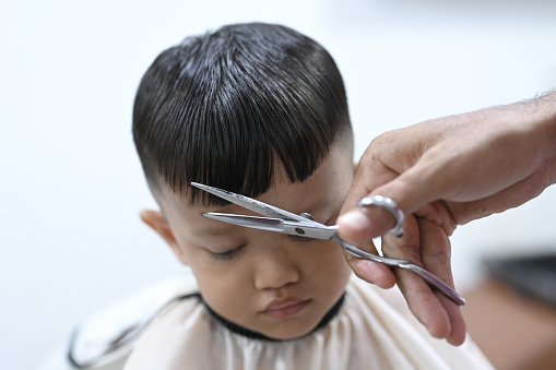 Trimming hair with scissors on boy