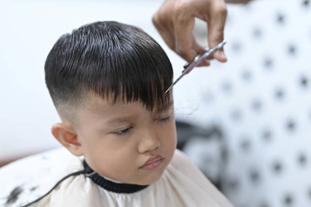 istock Trimming hair with scissors on boy 2104498086