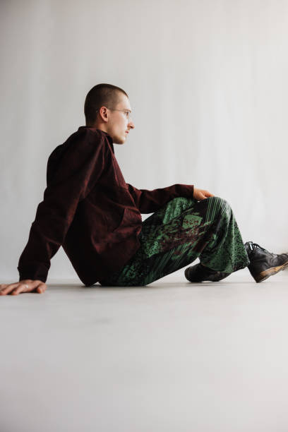 istock Man In Side Profile Sitting On The Ground With His Legs Slightly Bent 2104501380