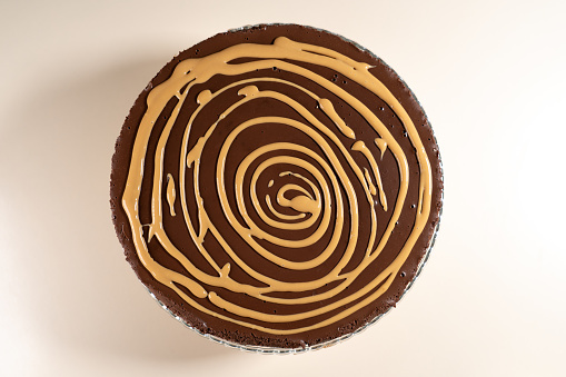 Cake decorating. Spiral from caramel sauce. Making Salted Caramel Chocolate Cold Cake Series.