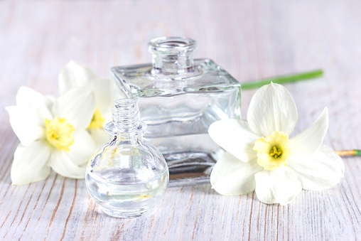Glass bottle or viials with essential oil and white daffodils