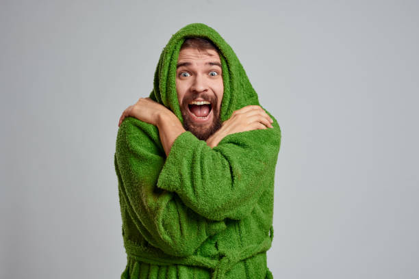 istock Bearded man in green robe cropped view gray background close-up 2104536676