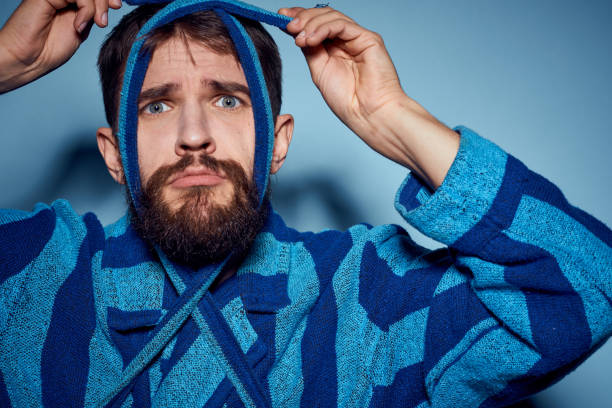 istock A man in a blue robe on a light background gestures with his hands model home clothes 2104537747