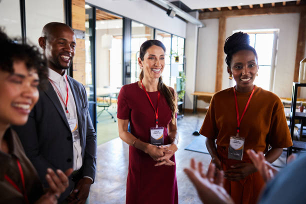 istock Group of smiling businesspeople talking in an open plan office space 2104538269