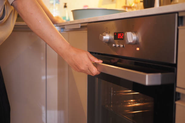 istock women hand open electric oven at home 2104547280