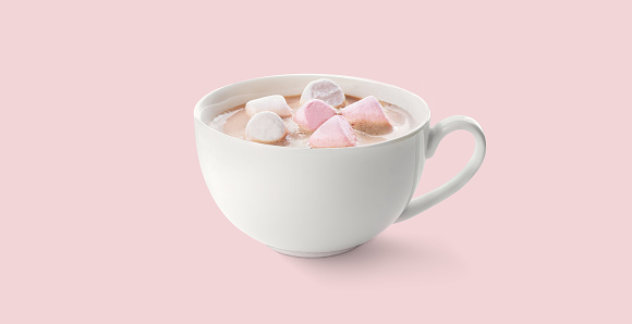 Cup of Hot chocolate with pink and white marshmallow on a pink background