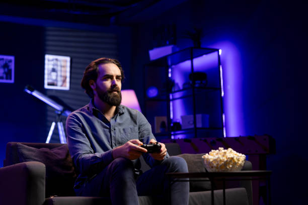 istock Man in home theatre playing engaging videogame 2104557272