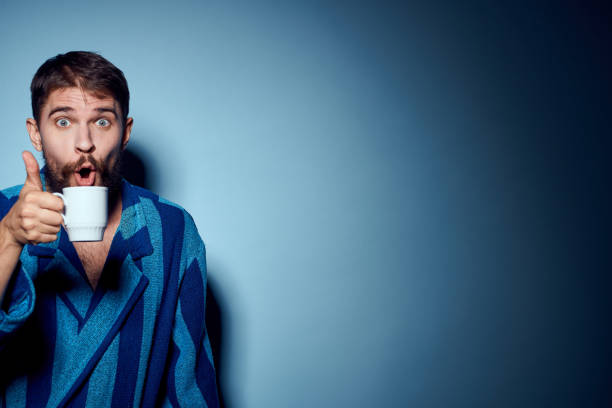 istock man in striped blue robe holding white cup in hand and emotions fun surprise model cropped view 2104565143