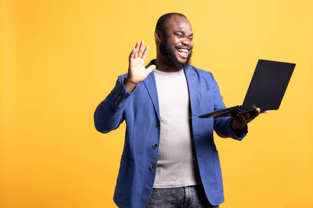 istock Joyful man greeting coworkers during teleconference meeting, studio background 2104567804