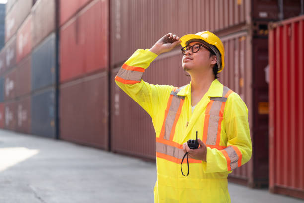 istock Asia logistic engineer man worker or foreman working with walkie talkie at container site 2104569897