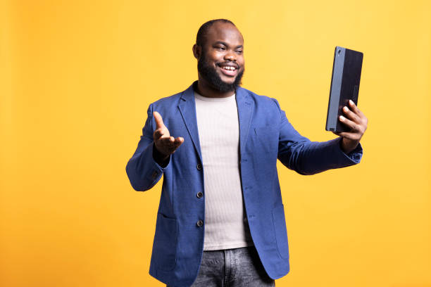 istock Smiling man in videocall on tablet,isolated over studio background 2104577345