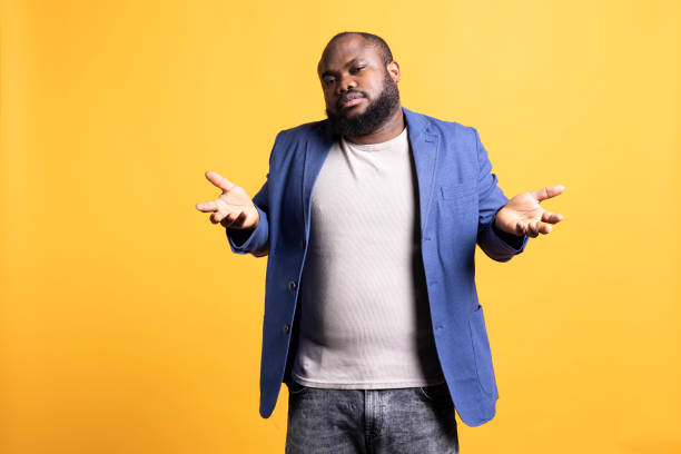 istock Uncaring man shrugging shoulders, showing indifference, studio background 2104580667