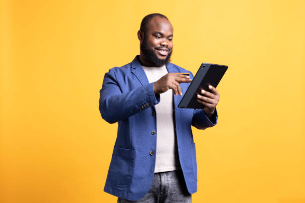 istock Upbeat man doing internet shopping, enjoying sales period, studio background 2104582233