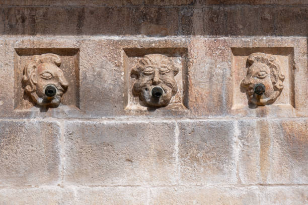 three old water pipes in a stone wall depicting qiq