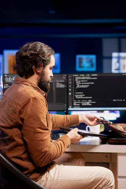 istock Man packing laptop in backpack after finishing doing software quality assurance 2104597352