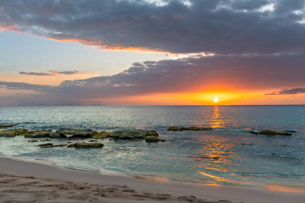 istock Orange sun setting on the horizon on a tropical beach with turquoise waters 2104600758