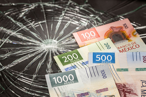 Mexico Money, Pesos Problems, Weakening of Mexican Currency, Bundle of Mexican Money on Broken Glass Background, Financial Concept or Insurance Costs