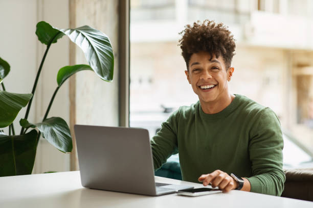 istock Cheerful millennial black man freelancer working at cozy cafe 2104631733