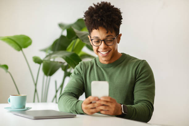 istock Happy young black guy freelancer working at cafe 2104631760