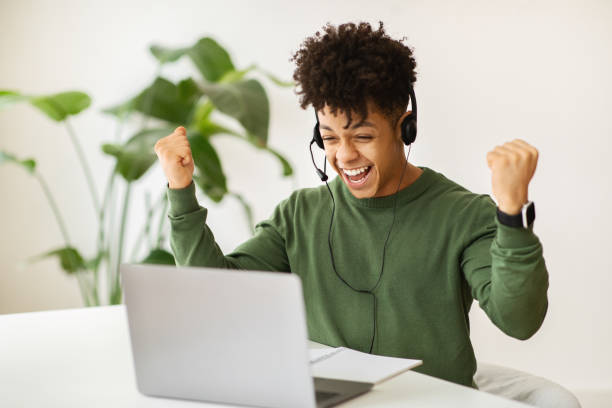 istock Excited black guy remote employee working at cafe 2104631769