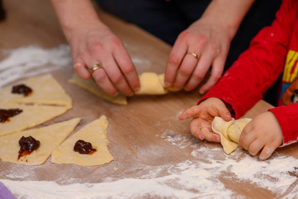 istock The child makes croissants with his mother 2104643904