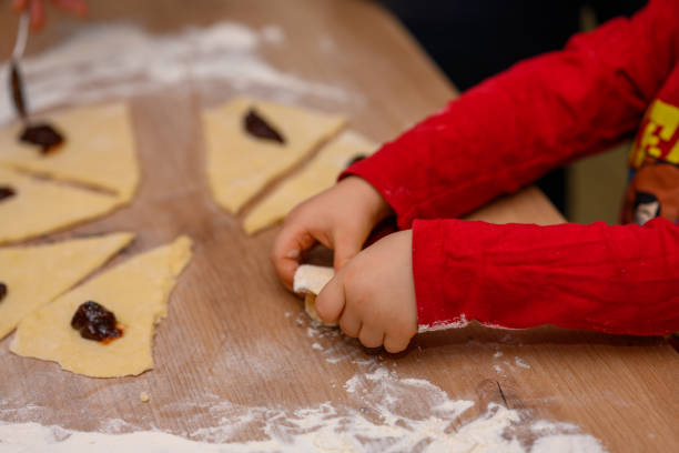 The child makes croissants with his mother