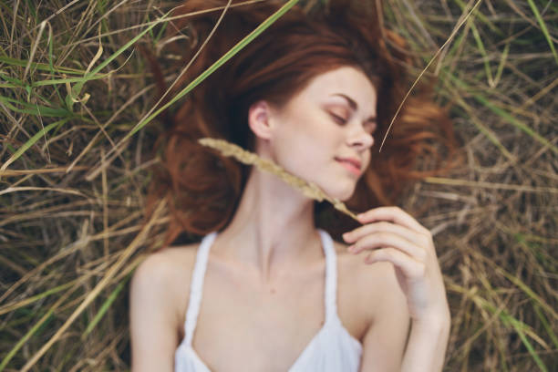 happy woman on dry grass laughs in nature. High quality photo
