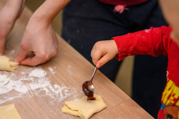 istock The child makes croissants with his mother 2104647138