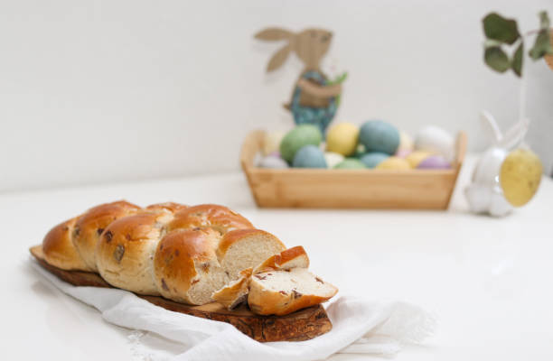 istock Cutted easter loaf bread on wooden plate on white table 2104648839