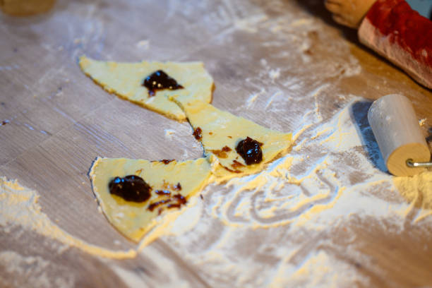 The child makes croissants with his mother