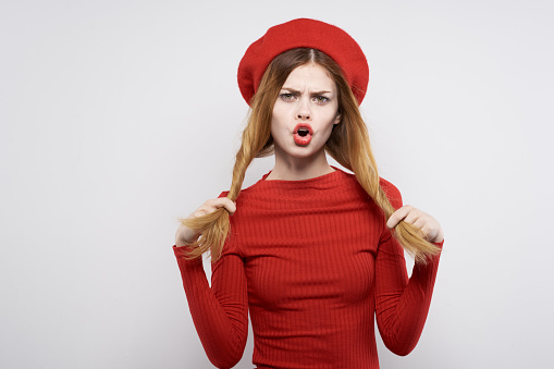 cheerful woman with a red cap on his head glamor light background. High quality photo