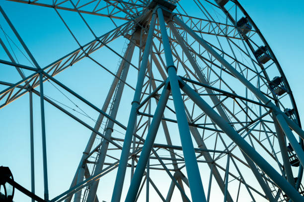 part of the Ferris wheel on a blue sky background, bottom view. metal construction on the Ferris wheel