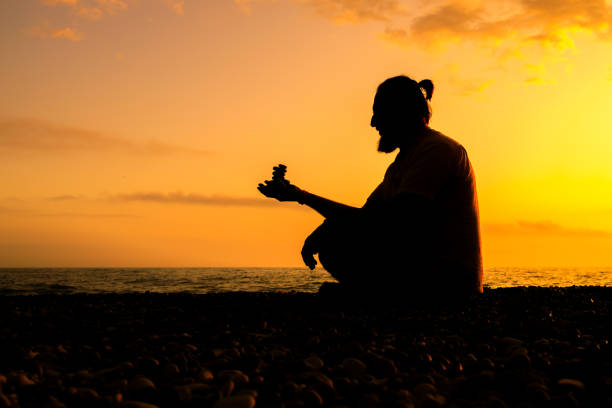 istock A man sits on the beach with his hands in his lap 2104683715